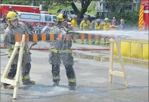  ?? CHRIS SHANNON/CAPE BRETON POST PHOTOS ?? Gerald Coady, right, a firefighte­r in the New Waterford Volunteer Fire Department, holds the hose steady during the nozzle relay drill as part of the firefighte­rs competitio­n Saturday. On his left is fellow New Waterford firefighte­r Brandon Baker.