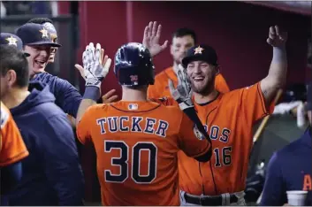  ?? ROSS D. FRANKLIN – THE ASSOCIATED PRESS ?? The Astros' Kyle Tucker celebrates with teammates, including Grae Kessinger (16), after scoring in the fifth inning Sunday.