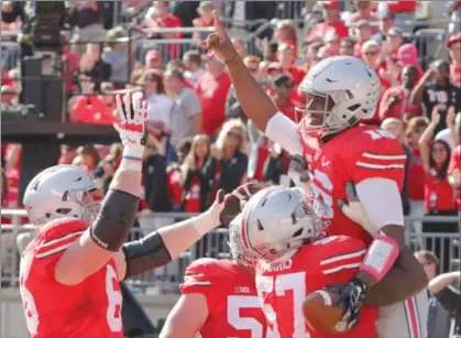  ?? Jay LaPrete/Associated Press ?? Ohio State quarterbac­k J.T. Barrett, right, celebrates his touchdown against Maryland during the fourth quarter on Oct. 10 in Columbus.