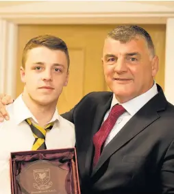  ??  ?? Second row David Richards receives the prestigiou­s 1st XV Players’ Player Award from Rowland Phillips