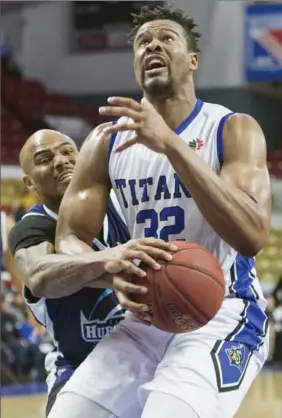  ?? ADAM GAGNON, SPECIAL TO THE RECORD ?? K-W Titans Paul Cooper gets fouled by Halifax Hurricanes Tryrone Watson during Friday night’s game at the Kitchener Auditorium. Titans lost the game 102-100.