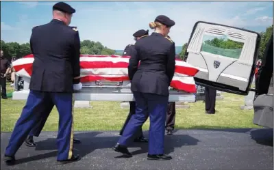  ??  ?? The casket of Cpl. Paul Wilkins is removed from the hearse June 26 at Logan Valley Cemetery in Bellwood, Pa.