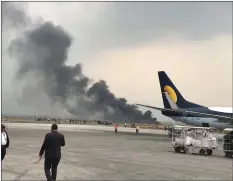  ??  ?? „ Smoke rises after the plane crashed just off the runway at Kathmandu.