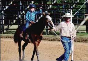  ??  ?? Astrid Freyja, 6, waves to rans while competing in the leadline division at Sunday’s Lincoln Riding Club Play Day. Her father, Anthony Karain, led her through the pole bending course.