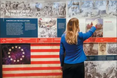  ?? JOHN MINCHILLO — THE ASSOCIATED PRESS ?? A staff member browses a display during a limited media availabili­ty at the National Veterans Museum and Memorial, Monday in Columbus.