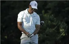  ??  ?? Tiger Woods reacts to his tee shot on the 14th hole during the second round of the Wells Fargo Championsh­ip golf tournament at Quail Hollow Club in Charlotte, N.C., on Friday. AP PHOTO/CHUCK BURTON