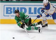  ?? LM Otero/Associated Press ?? Dallas Stars center Joe Pavelski reaches for the puck next to Buffalo Sabres center Tyson Jost during the first period of an NHL game in Dallas on Tuesday.