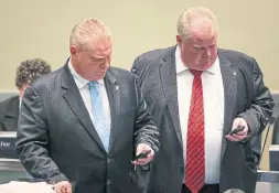  ?? DAVID COOPER TORONTO STAR FILE PHOTO ?? Toronto Councillor Doug Ford and Mayor Rob Ford check their phones at city council in November 2013.