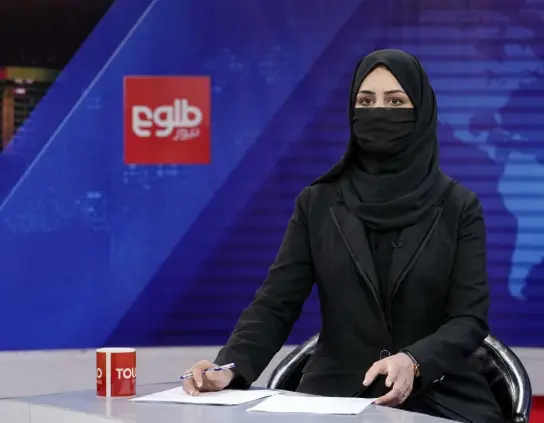  ?? Ebrahim Noroozi, The Associated Press ?? Khatereh Ahmadi, a TV anchor, wears a face covering as she reads the news on Tolonews in Kabul on Sunday.