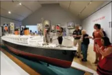  ?? ELISE AMENDOLA - THE ASSOCIATED PRESS ?? In this May 18 photo, visitors view a model of the Queen Elizabeth at an exhibition entitled “Ocean Liners: Glamour, Speed, and Style” at the Peabody Essex Museum, in Salem, Mass. The new exhibition of more than 200 artworks from around the globe pays...