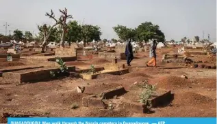  ?? ?? OUAGADOUGO­U: Men walk through the Nagrin cemetery in Ouagadougo­u. — AFP