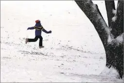  ?? CHARLIE RIEDEL AP ?? A boy runs down a snowy hill at a park in Shawnee, Kan. Saturday after a winter storm dumped several inches of snow on the area.