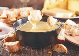  ??  ?? The Swiss national dish consists of cheese melted down with white wine in a “caquelon” pot heated by an open flame.