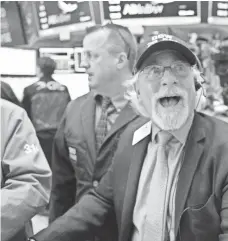  ?? AFP/GETTY IMAGES ?? A trader reacts as the Dow closes above 20,000 for the first time at the New York Stock Exchange on Jan. 25.