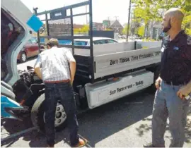  ?? STAFF PHOTO BY TIM OMARZU ?? Michael Walton, left,executive director of Green Spaces and Mike Holtzhower, in market ing and servicing at Southeast Diesel Inc., look over a prototype all-electric work truck made by Mitsubishi Fuso Truck and Bus Corp. Thursday in a parking lot near...