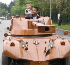  ?? — AFP photo ?? Truong Van Dao and his son ride in a wooden tank made from the conversion of an old minibus in a residentia­l area in Bac Ninh province.