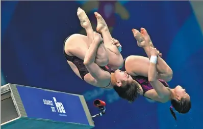  ?? TIBOR ILLYES/MTI VIA AP ?? China’s Ren Qian and Si Yajie compete en route to winning the gold medal in the women's 10m synchroniz­ed platform diving final at the World Aquatics Championsh­ips in Budapest, Hungary, on Sunday. In other results, Peng Jianfeng clinched the men’s 1m...
