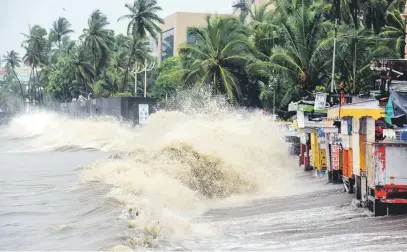  ?? Picture: AFP ?? Waves hit shops and structures built along the coast during monsoon in Mumbai yesterday.