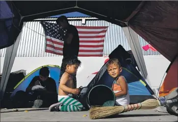  ?? Gary Coronado Los Angeles Times ?? HONDURAN BROTHERS Isaac, left, and Carlitos Dueñas sit at a migrant camp in Tijuana in 2018. Under “Remain in Mexico,” nearly 60,000 people have been forced to wait in Mexico for their asylum cases to proceed.