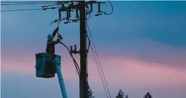  ?? RICH PEDRONCELL­I/AP 2018 ?? A Pacific Gas & Electric lineman works to repair a power line in fire-ravaged Paradise, California.