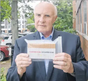  ?? .*5$) ."$%0/"-% 5)& (6"3%*"/ ?? Gary Grant, spokespers­on for the National Coalition Against Contraband Tobacco, holds up a mock back of illegal cigarettes after meeting with officials in Charlottet­own on Tuesday.