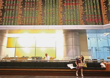  ??  ?? Volatile market: An investor monitors stock market prices in Kuala Lumpur. Most analysts are hoping for a better year for the stock market next year but say volatility will continue to prevail.