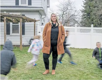  ?? Andrew Mangum, © The New York Times. Co. ?? A long-exposure photograph shows Kate Baer, author of “What Kind of Woman,” as her children play outside her home in Hummelstow­n, Pa., on Jan. 4. In a year in which all people, but perhaps especially mothers, are grasping for words to express their exhaustion and anger, in Baer they have foundsomeo­netosayitf­orthem.