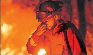  ?? Josh Edelson AFP/Getty Images ?? AN INMATE firefighte­r pauses as the Carr fire, blamed for eight deaths, burns in Redding on July 27.