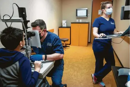  ?? Brett Coomer / Staff file photos ?? Dr. Aaron M. Miller examines Noah Garcia as orthoptist Angela Dillon takes notes at Houston Eye Associates in The Woodlands in April. During a visit to a doctor, it’s advised to keep a mask on and to not forget hand sanitizer.