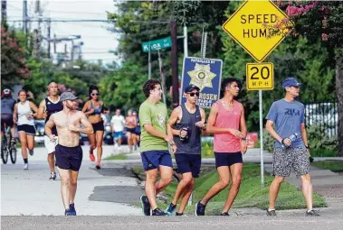  ?? Michael Wyke / Contributo­r ?? Runners with the Kung Fu Running Club make it through traffic after crossing Westcott on Blossom near Memorial Park. Runners say the crossing is made difficult by vehicle speeds and a lack of a signal or nearby signs.