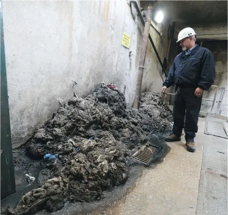  ?? PHOTOS: JASON KRYK ?? Robert Budway, team leader for the Ontario Clean Water Agency, inspects a pile of flushable wipes that were removed from LaSalle Pumping Station No. 1 in LaSalle on Monday. Fats, grease and oils can also form costly clogs in sewers and pumping stations.