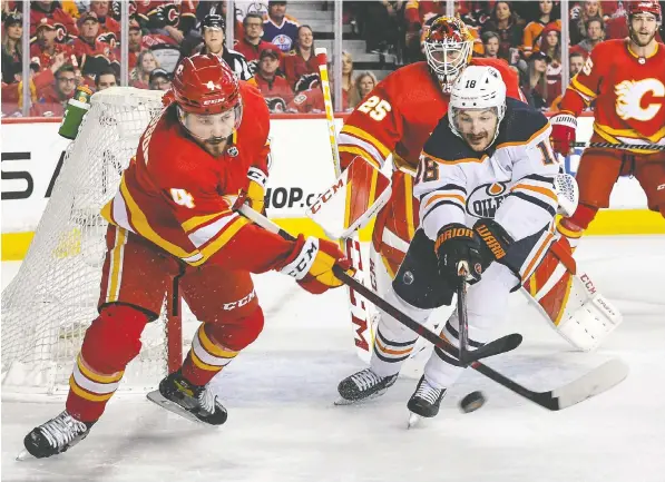  ?? GETTY IMAGES ?? Calgary's Rasmus Andersson, left, seen here battling for the puck with Zach Hyman of the Edmonton Oilers in Game Two at Scotiabank Saddledome on Friday, recognized that “we took a few penalties and kind of let them get back into it.”