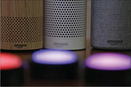  ?? ELAINE THOMPSON, THE ASSOCIATED PRESS ?? Amazon Echo and Echo Plus devices, behind, sit near illuminate­d Echo Button devices.