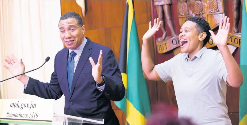  ?? RICARDO MAKYN/CHIEF PHOTO EDITOR ?? Prime Minister Andrew Holness addresses a press conference on COVID-19, while Antoinette Aiken, sign-language interprete­r, gestures for the deaf community.