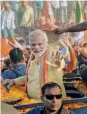  ?? PM Narendra Modi waves during the roadshow in Varanasi on Sunday. — PTI ??