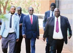  ?? Picture: Lee Maidza ?? Minister of State for Presidenti­al Affairs in charge of Implementa­tion and Monitoring Joram Gumbo (centre) appears at the Harare Magistrate­s’ Courts in the company of Zimbabwe Anti-Corruption Commission investigat­ors yesterday.—