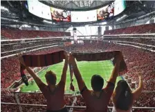  ?? THE ASSOCIATE DPRESS ?? Atlanta United FC fans cheer before Saturday’s home match against Orlando City. The crowd of 70,245 set an MLS attendance record.