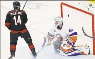  ?? Gerry Broome / Associated Press ?? The Carolina Hurricanes’ Justin Williams (14) scores the game-winning goal against New York Islanders goalie Robin Lehner during the third period of Game 3 of a second-round playoff series in Raleigh, N.C., Wednesday.