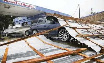  ?? ELIZABETH CONLEY Houston Chronicle via AP ?? Parts of a roof sit on top of a vehicle following Hurricane Nicholas in Bay City, Texas on Tuesday.