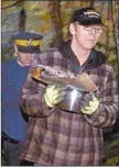  ??  ?? A protester carries the sacred fire out of a campsite that was the home of about 30 people attempting to halt logging in a grove of hemlock trees. Police raided the camp Friday and removed the protesters and then the logging began.