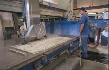  ??  ?? Cutter Joel Darling makes a custom order counter top at Take Us for Granite on Lancing Drive.