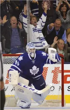  ?? RICHARD LAUTENS/TORONTO STAR ?? Leafs goalie Jonathan Bernier, like the fans behind him, is jubilant after he halted Ottawa’s final chance in the shootout to close a 5-4 win in their home opener.