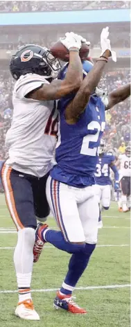  ?? AL BELLO/GETTY IMAGES ?? Bears receiver Allen Robinson grabs the ball off B.W. Webb’s helmet on a second-quarter pass play.