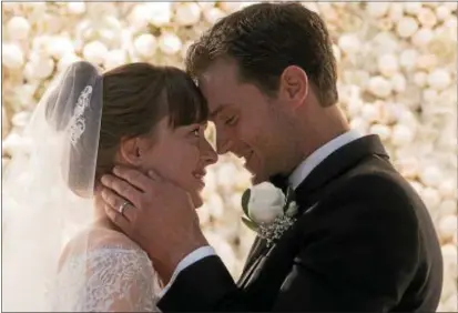 ?? PHOTO COURTESY OF UNIVERSAL PICTURES ?? Dakota Johnson’s Anastasia and Jamie Dornan’s Christian are wed early in “Fifty Shades Freed.”