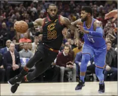  ?? AP PHOTO/TONY DEJAK ?? Cleveland Cavaliers’ LeBron James (left) drives against Oklahoma City Thunder’s Paul George (right) in the first half of an NBA basketball game Saturday in Cleveland.