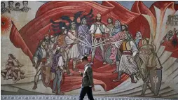  ?? — AP ?? A man passes an ethnic Albanian mural in Skopje, Macedonia, on Monday. Macedonia’s government faced a looming political battle on Monday to push through a deal with Greece that would ultimately pave the way for Nato membership, after a referendum on the agreement won overwhelmi­ng support but with low voter turnout.