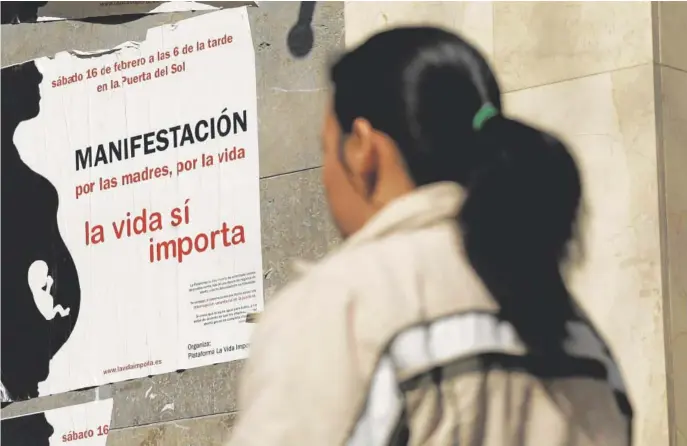  ?? // F. SECO ?? Una mujer cubana pasa delante de un cartel que anuncia una marcha antiaborti­sta en Madrid