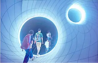  ?? CHINA DAILY ?? VISITORS walk into a 'black hole' at the newly unveiled Shanghai Astronomy Museum. The museum, the world's largest planetariu­m in terms of building scale, opened on 17 July.