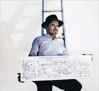  ?? Gina Ferazzi Los Angeles Times ?? ARTIST Emigdio “Higgy” Vasquez displays a sketch of a mural he’ll paint at Chapman University.