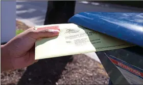  ?? (File Photo/AP/Miami Herald/David Santiago) ?? Miami-Dade resident James Curity deposits a ballot in a U.S. Postal Service mailbox Oct. 28, 2020, outside City Hall during early voting for the general election in Miami Beach, Fla. Stories circulatin­g online incorrectl­y claim absentee ballots will not be accepted unless voters mail them with up to two stamps.